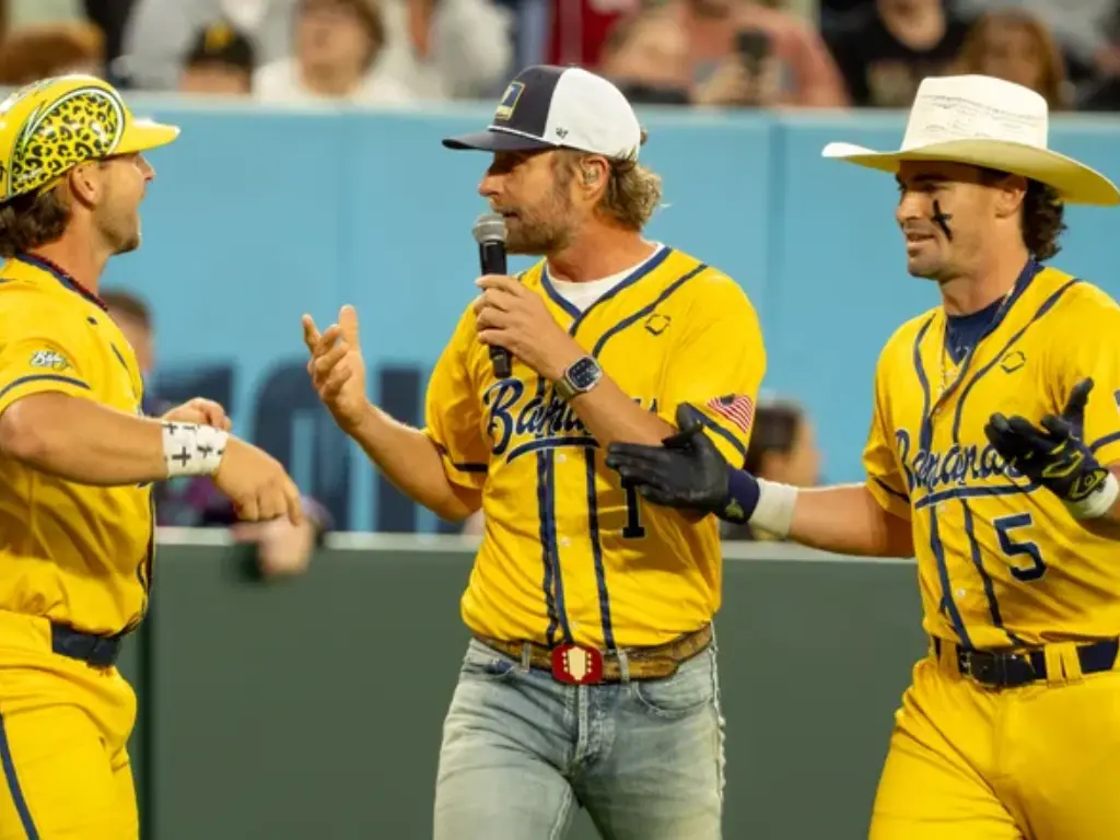 Country music singer Dierks Bentley, center, joins Savannah Bananas Bill Leroy (1) and Savannah Bananas David Meadows (5) to sing a song during their game against the Party Animals at Nissan Stadium in Nashville, Tenn., Saturday, May 10, 2025.